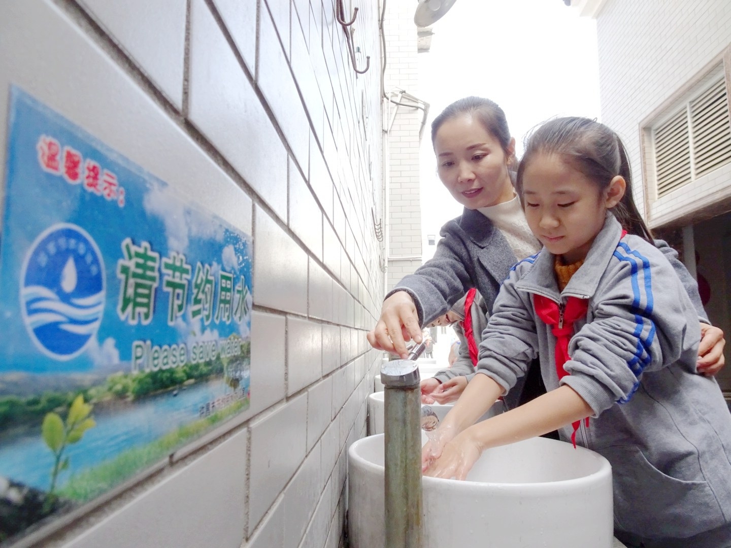10月17日,市节约用水办公室工作人员董淑敏在为孩子演示水龙头正确的